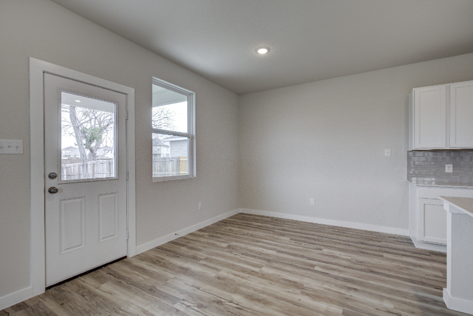 A room with a wood floor and a white door.