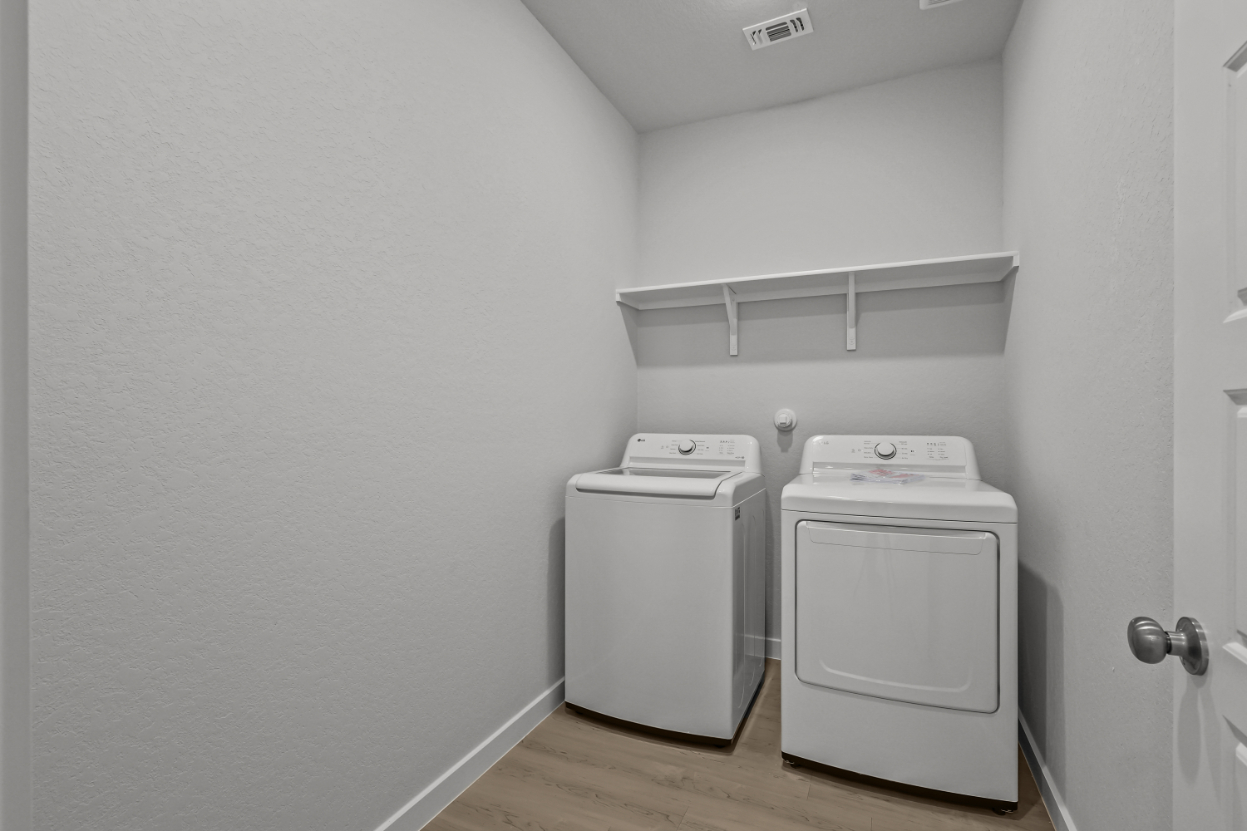 A white room with a washing machine and a dryer.