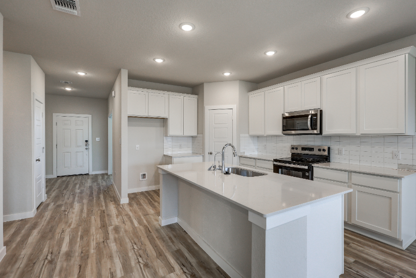 A kitchen with white cabinets.
