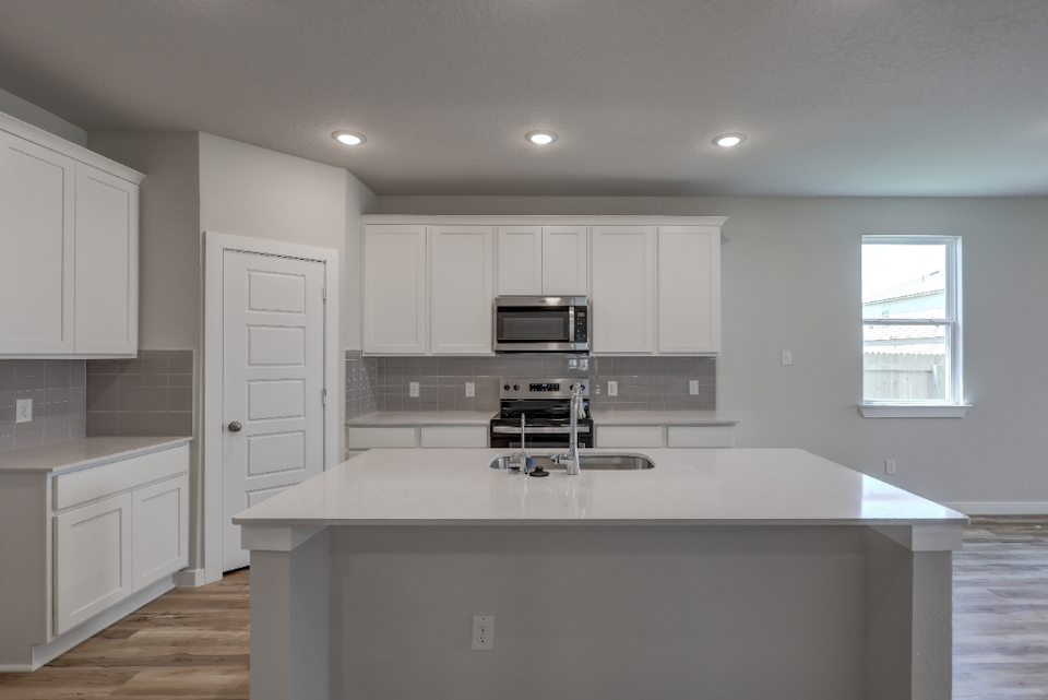 A kitchen with white cabinets.