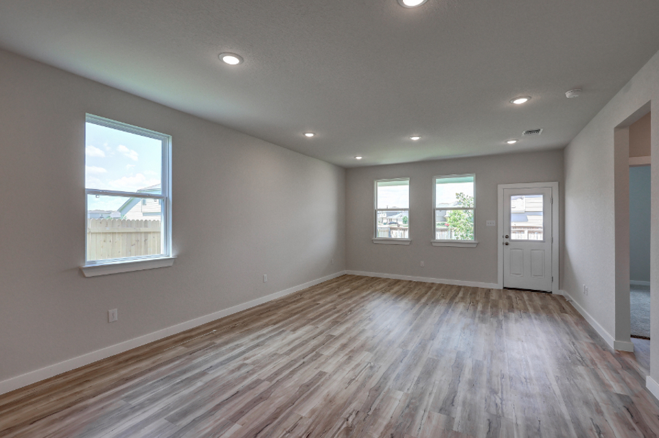 A room with a wood floor and windows.