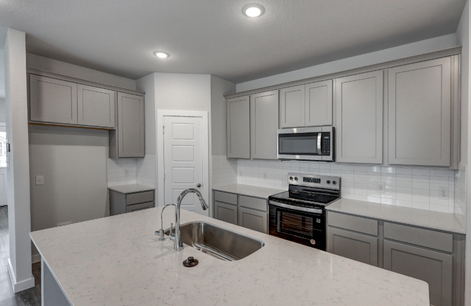 A kitchen with white cabinets.