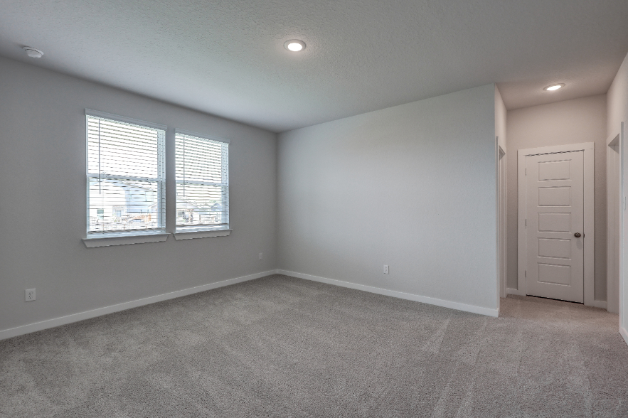 A room with a white door and a white wall with a window.