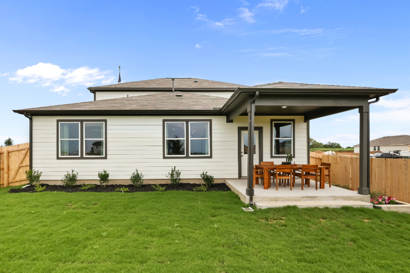 A house with a fence and lawn.
