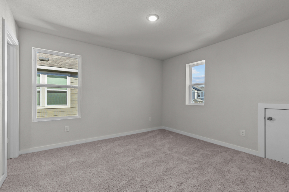 A room with a carpet and windows.