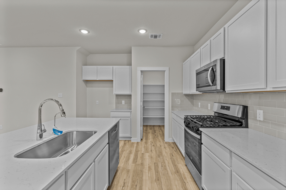 A kitchen with white cabinets.