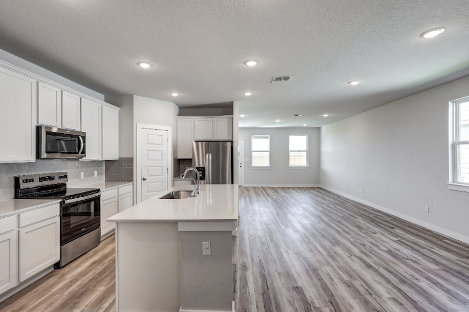 A kitchen with white cabinets.