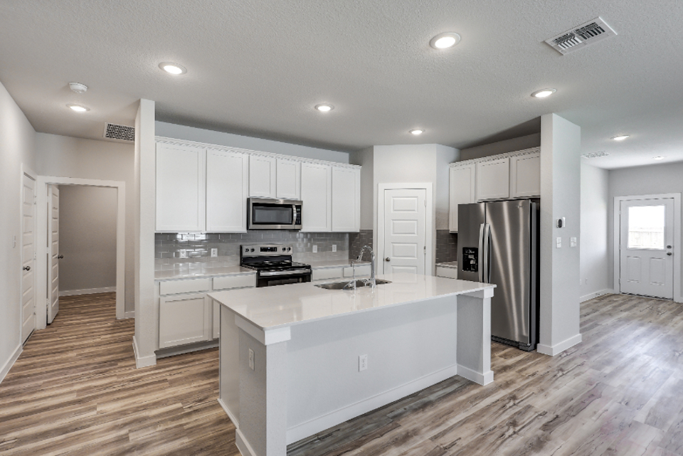 A kitchen with white cabinets.