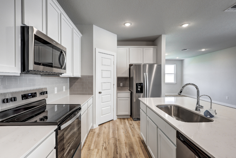 A kitchen with white cabinets.