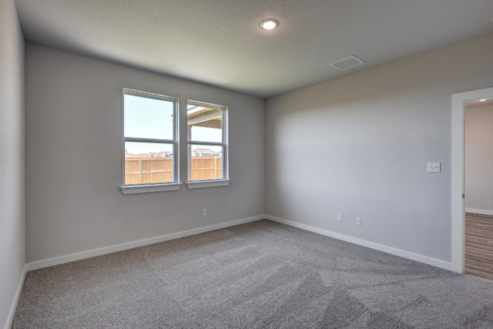 A room with a window and a carpet.