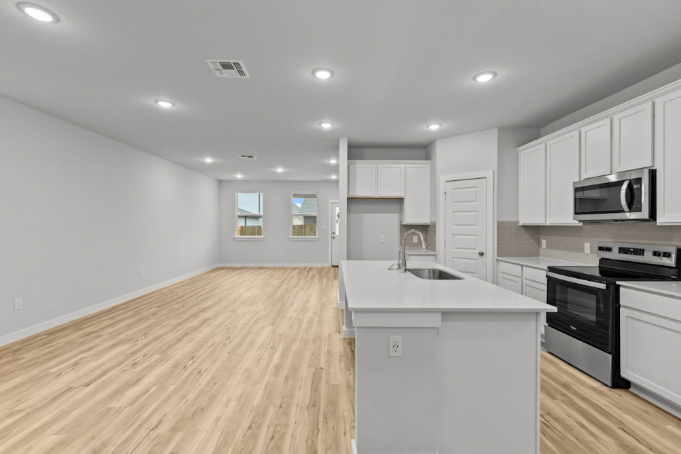 A kitchen with white cabinets.