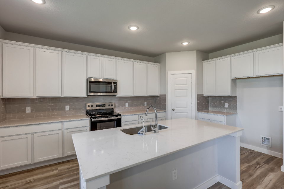 A kitchen with white cabinets.