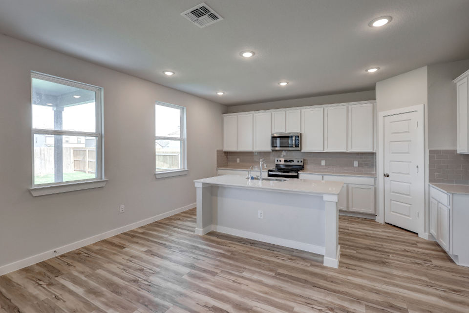 A kitchen with white cabinets.