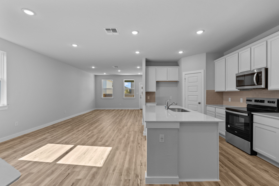 A kitchen with white cabinets.