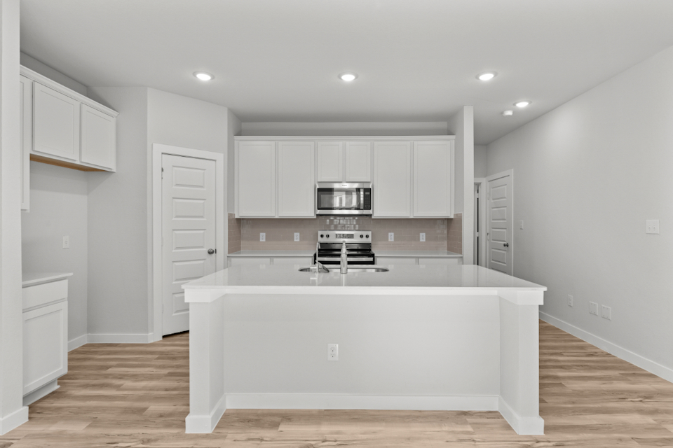 A kitchen with white cabinets.