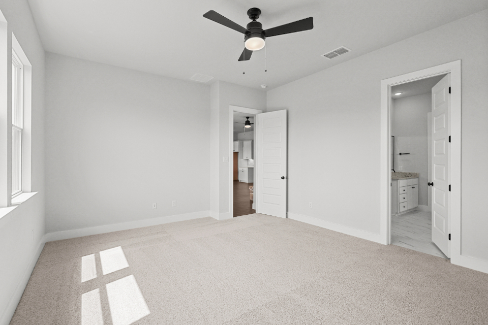 A room with a ceiling fan and a door.