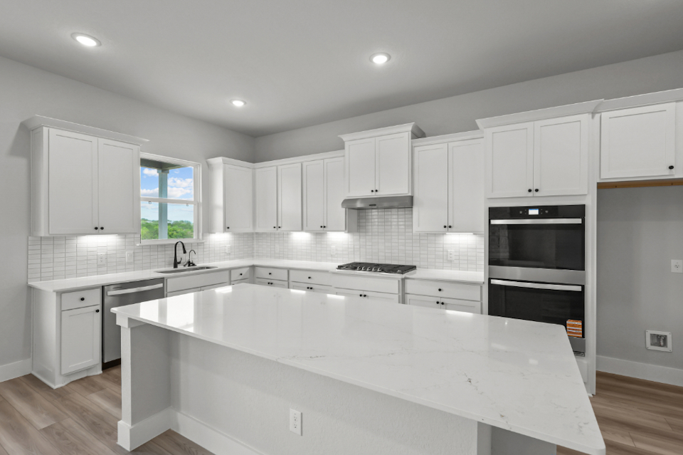 A kitchen with white cabinets.