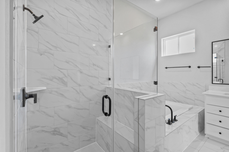 A bathroom with a shower unit and sink.