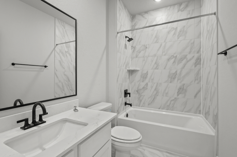 A bathroom with a shower and sink.