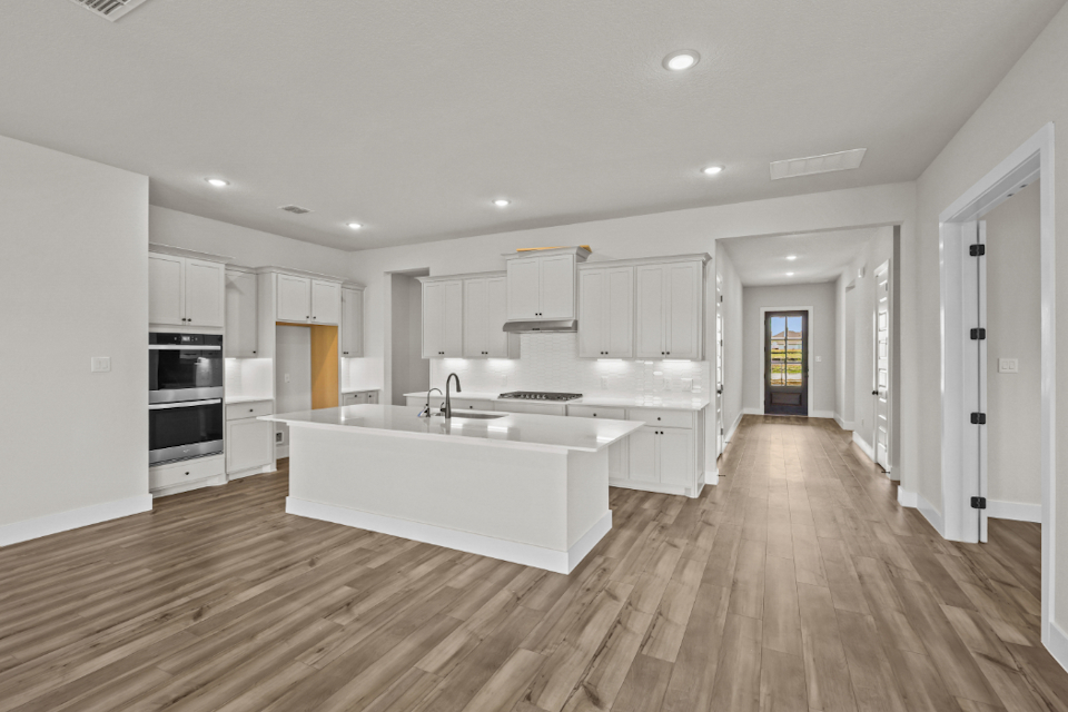 A kitchen with white cabinets.