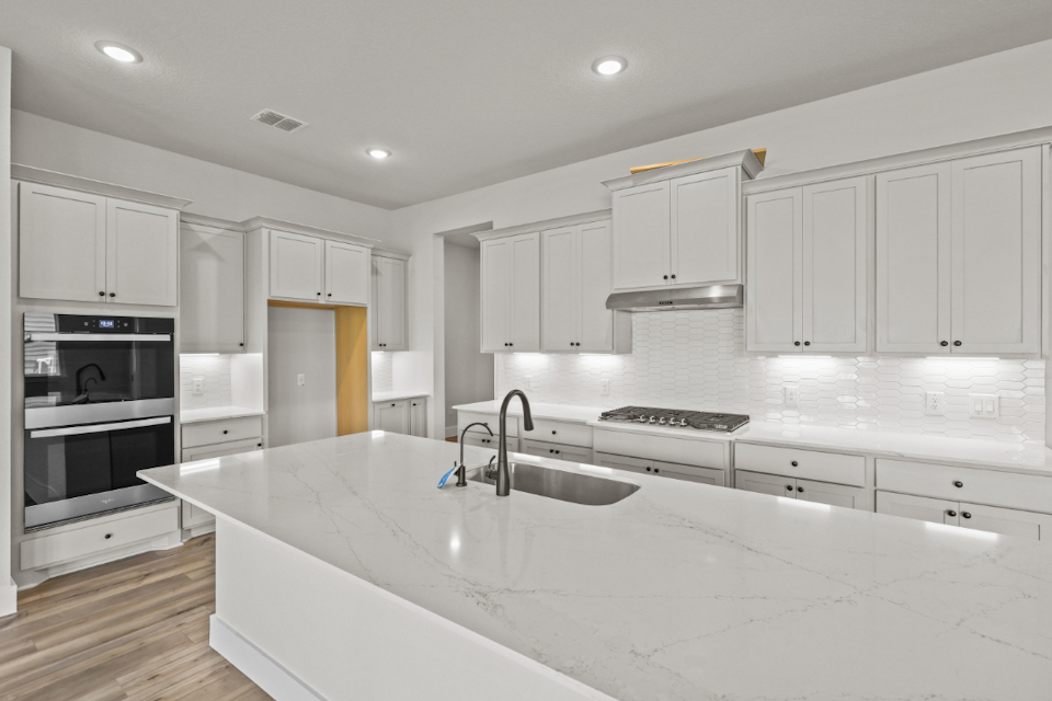 A kitchen with white cabinets.