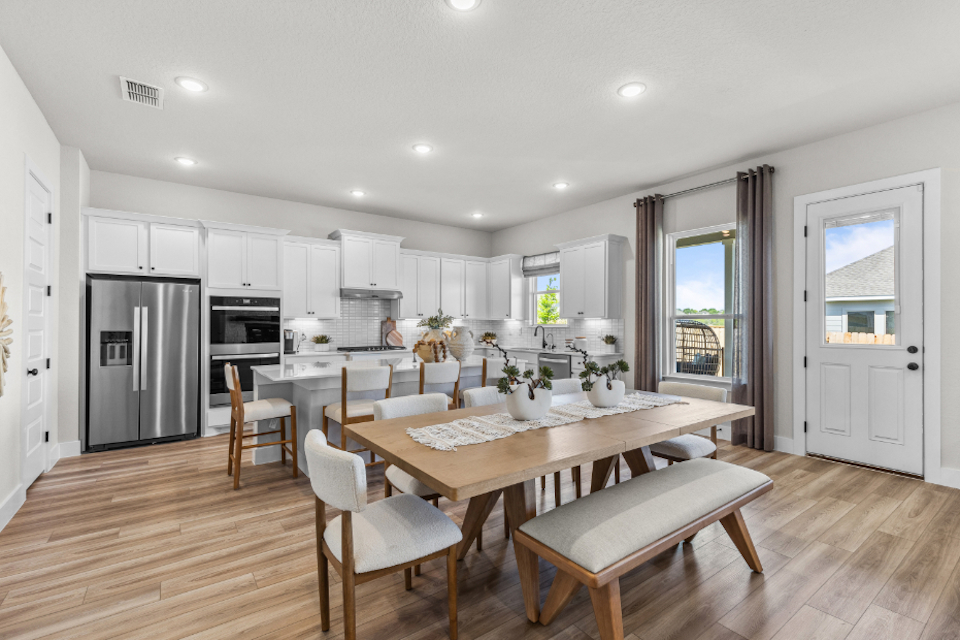A kitchen with a dining table and chairs.