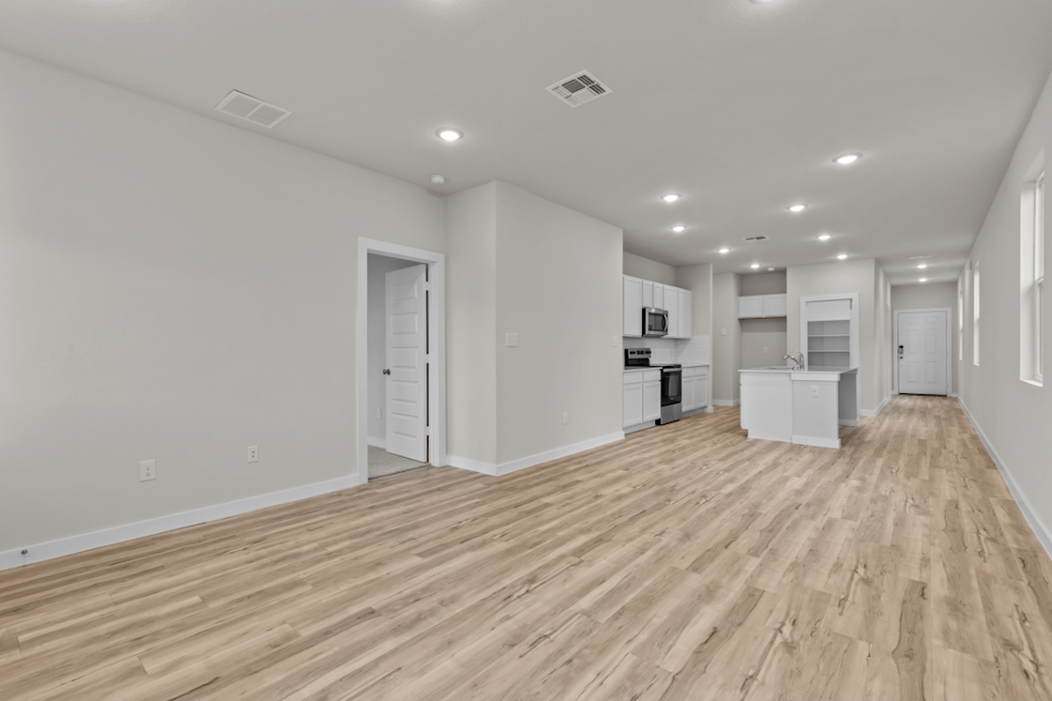 A room with white walls and wood floors.