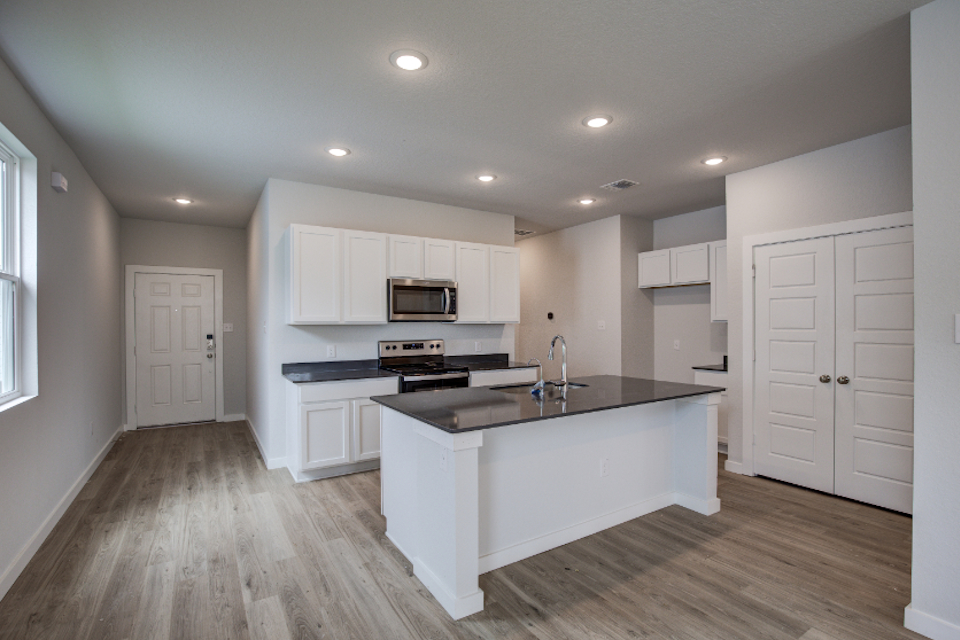 A kitchen with white cabinets.