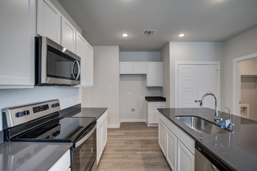 A kitchen with white cabinets.