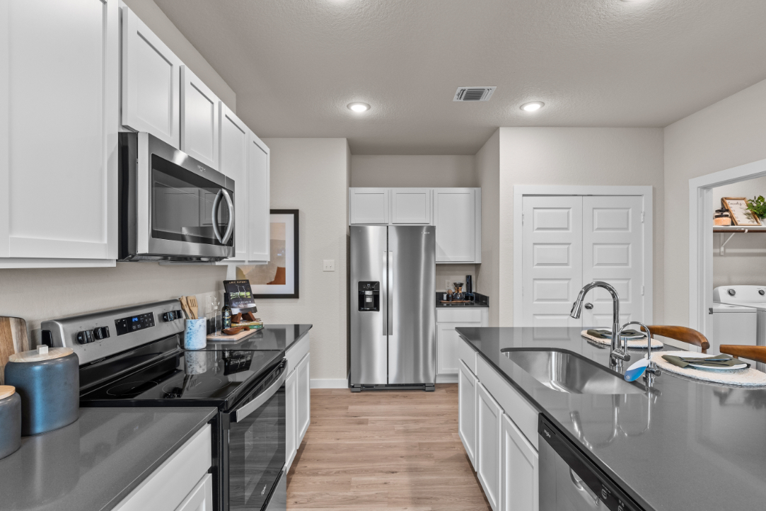 A kitchen with white cabinets.