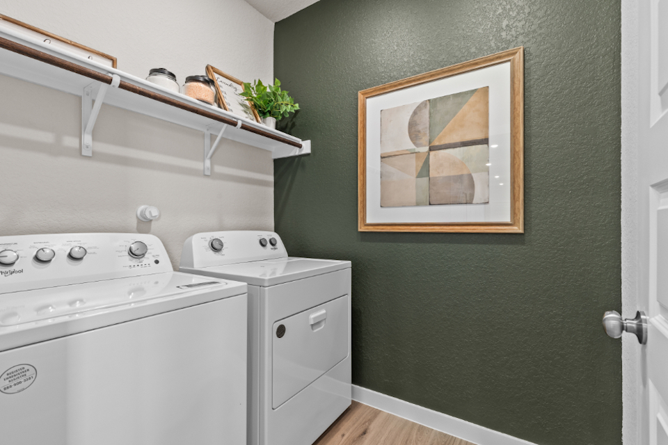 A white laundry room with a white washer and dryer.