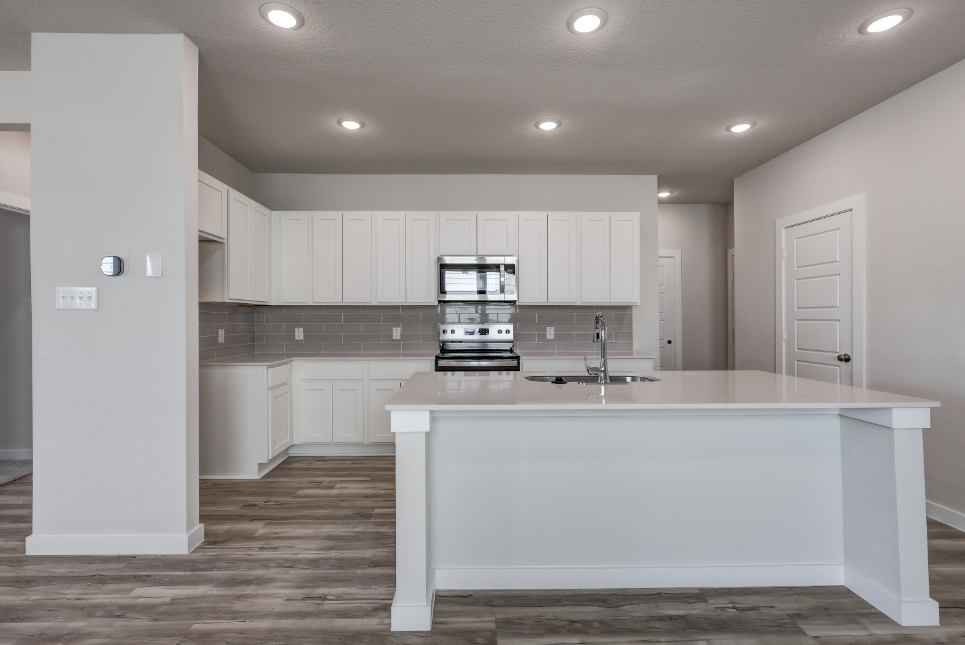 A kitchen with white cabinets.