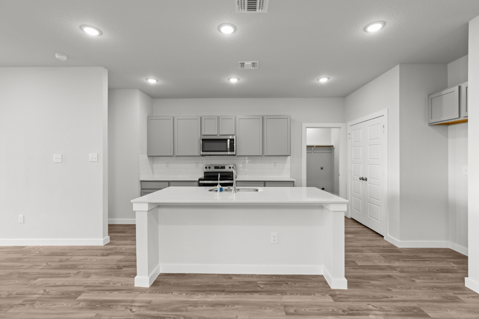 A kitchen with white cabinets.