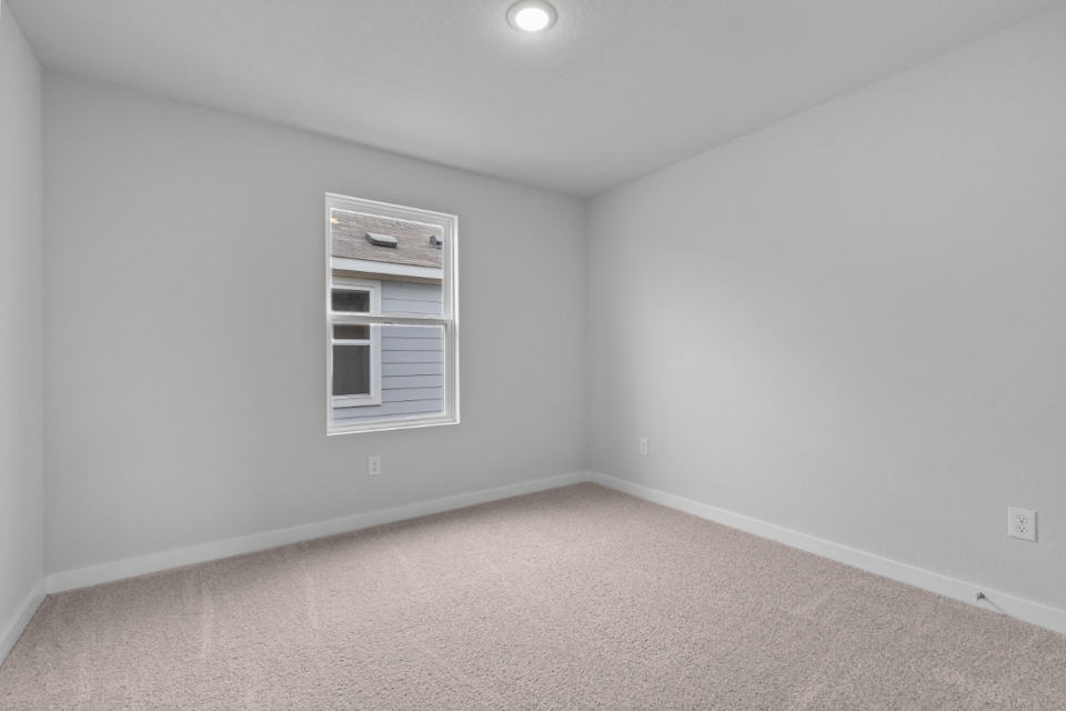 A room with a window and a carpet.