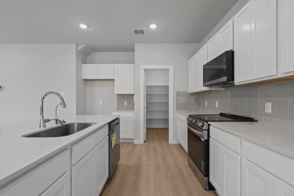 A kitchen with white cabinets.