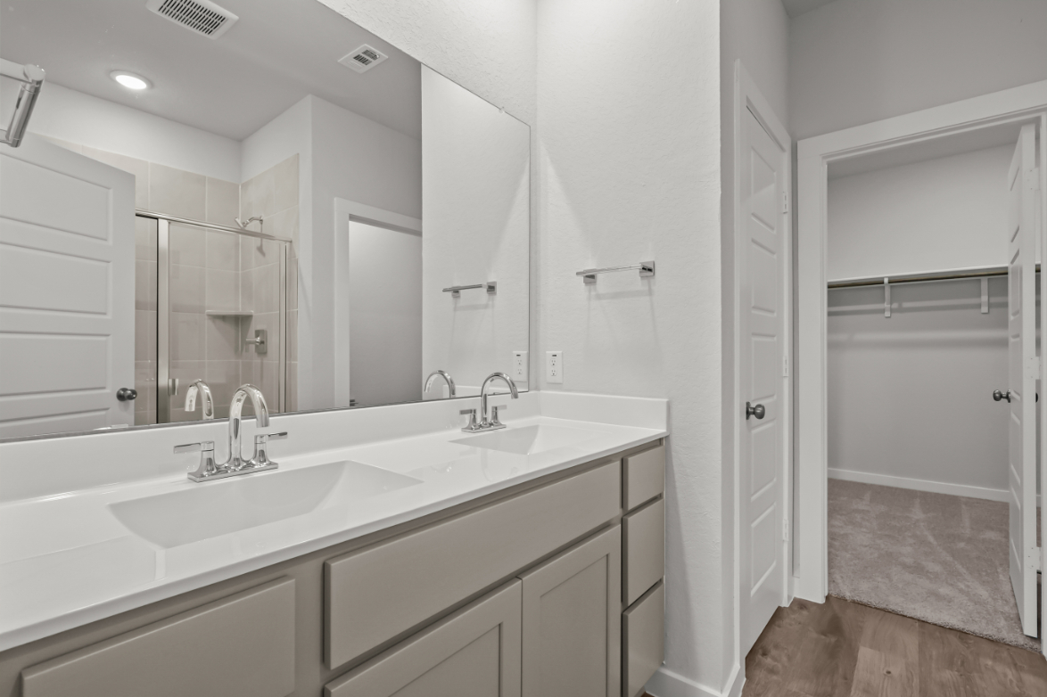 A bathroom with a sink and a shower unit.