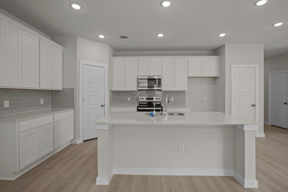 A kitchen with white cabinets.