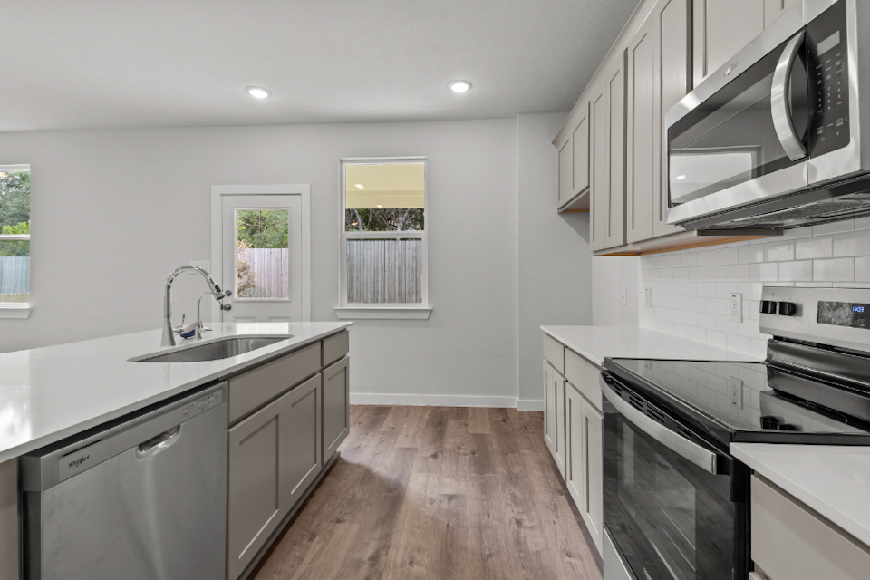 A kitchen with white cabinets.