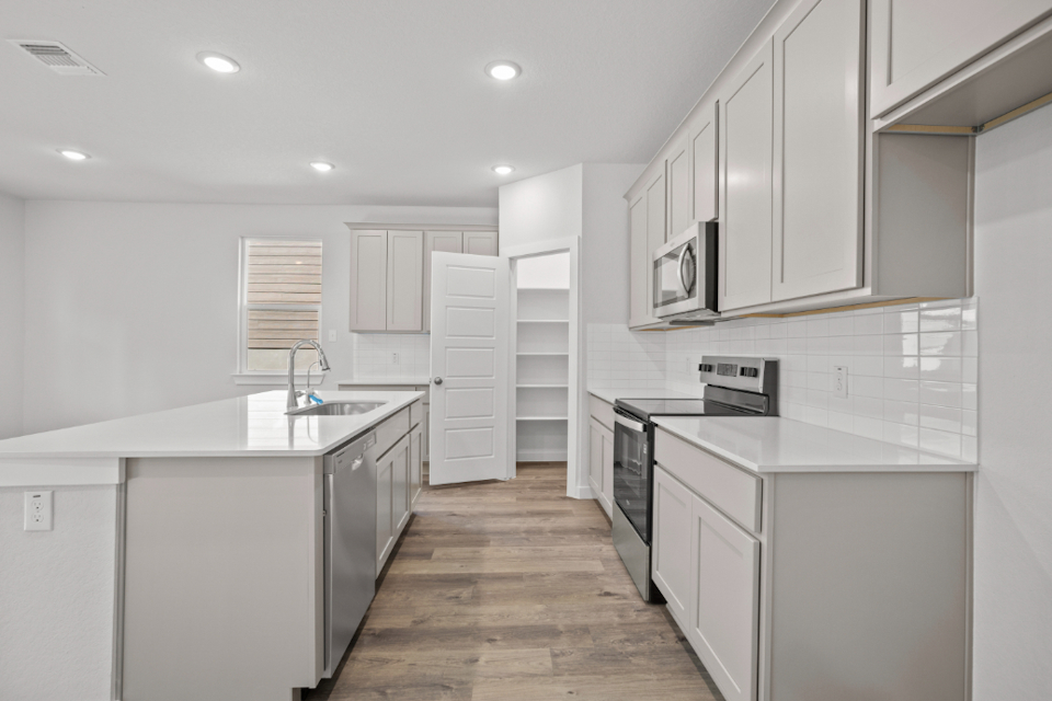 A kitchen with white cabinets.