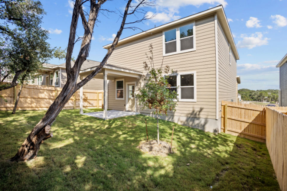 A house with a fence and trees.
