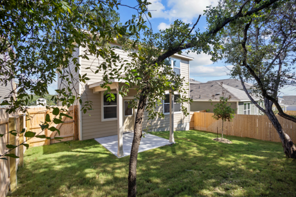 A backyard with a fence and trees.