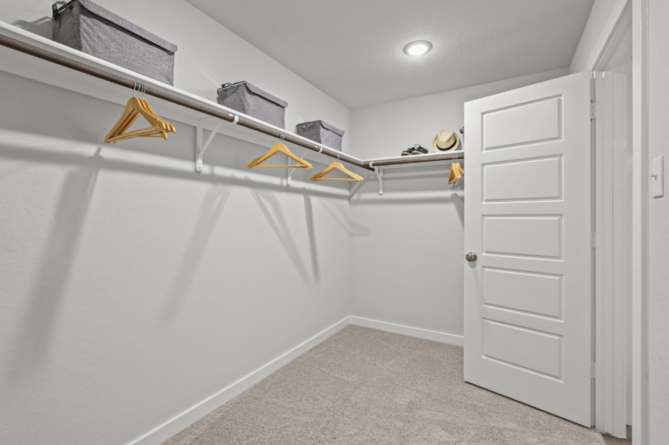 A room with white walls and a white door with yellow tape on it.