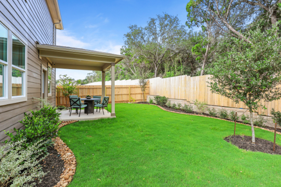 A backyard with a fence and a tree.