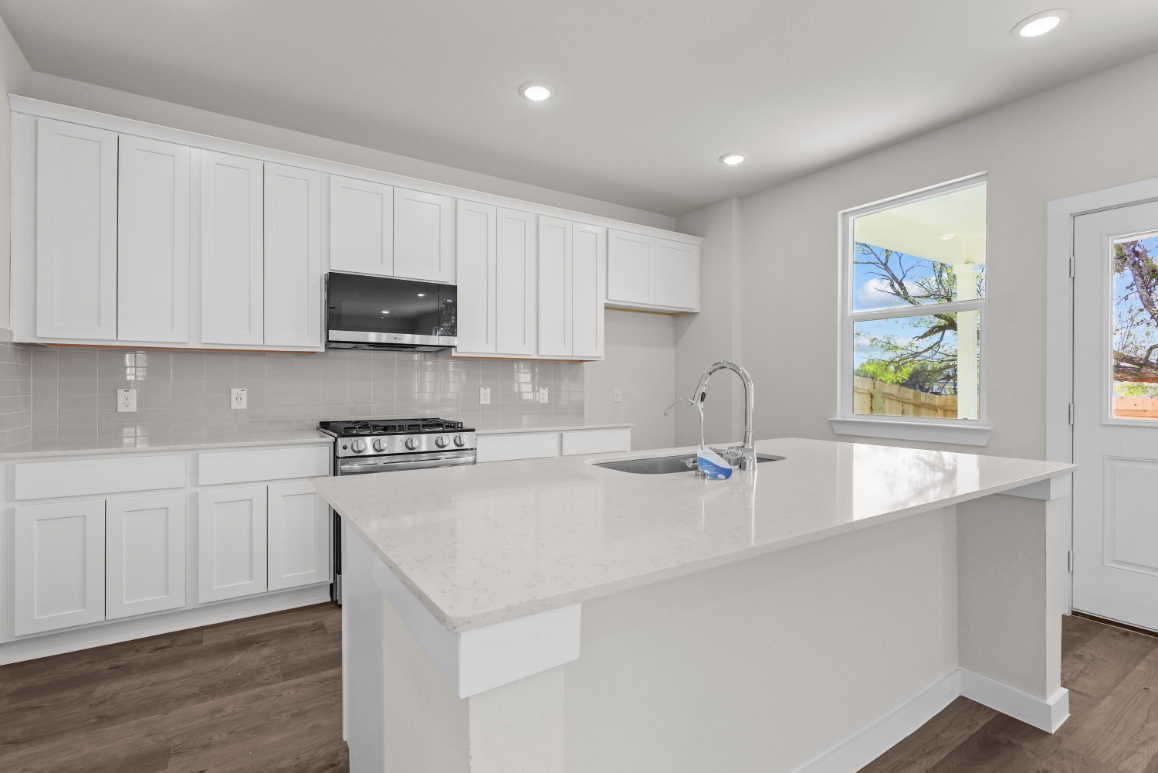 A kitchen with white cabinets.