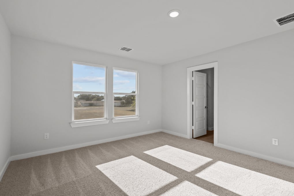 A room with a window and a rug.