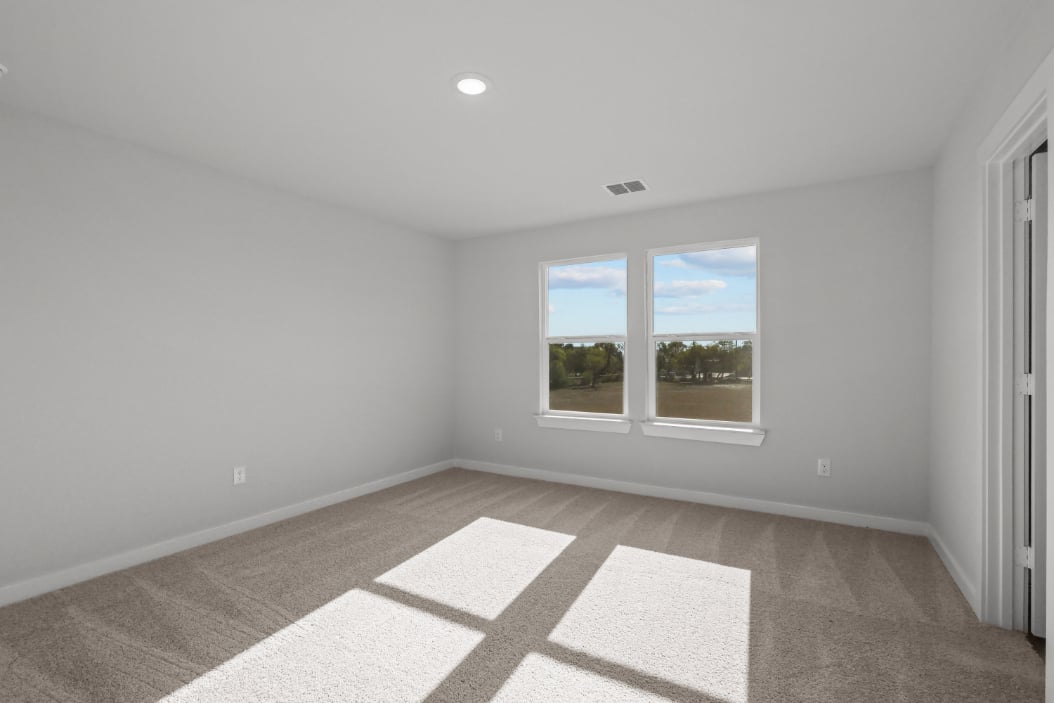 A room with a window and a rug.