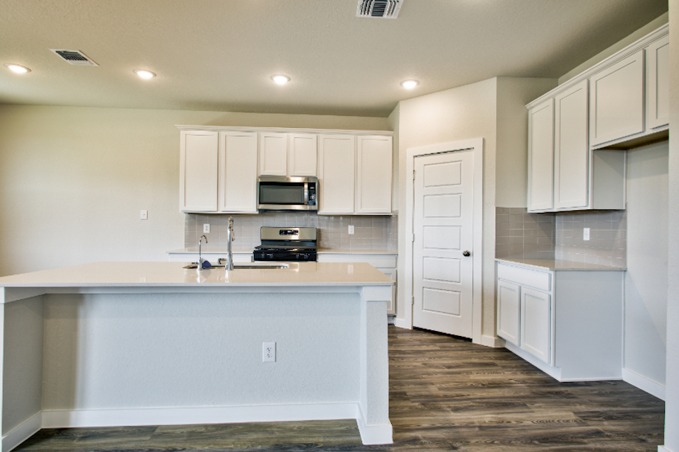 A kitchen with white cabinets.