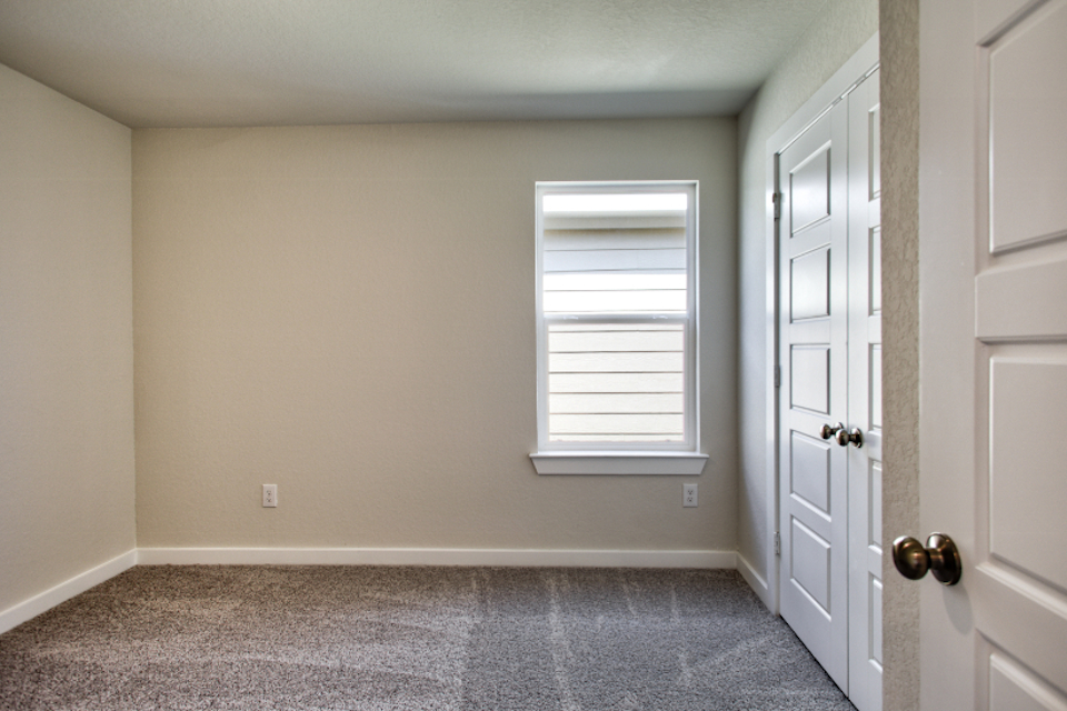 A room with white doors and a window.