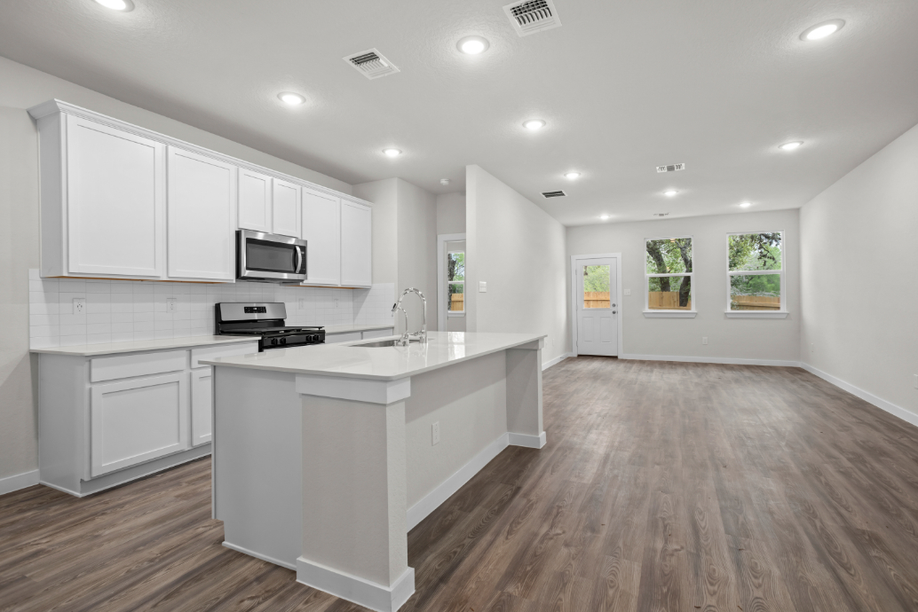 A kitchen with white cabinets.