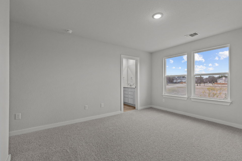 A room with a window and a door with a view of the city.